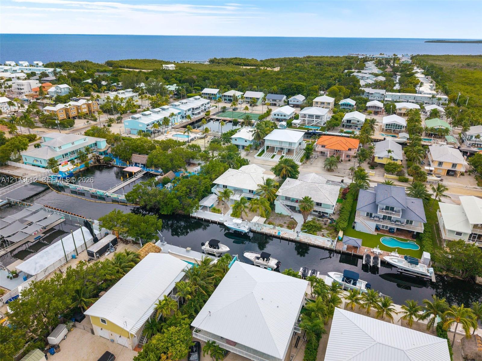 Aerial perspective of waterfront properties featuring deep-water canal access, private boat docks, and established coastal vegetation