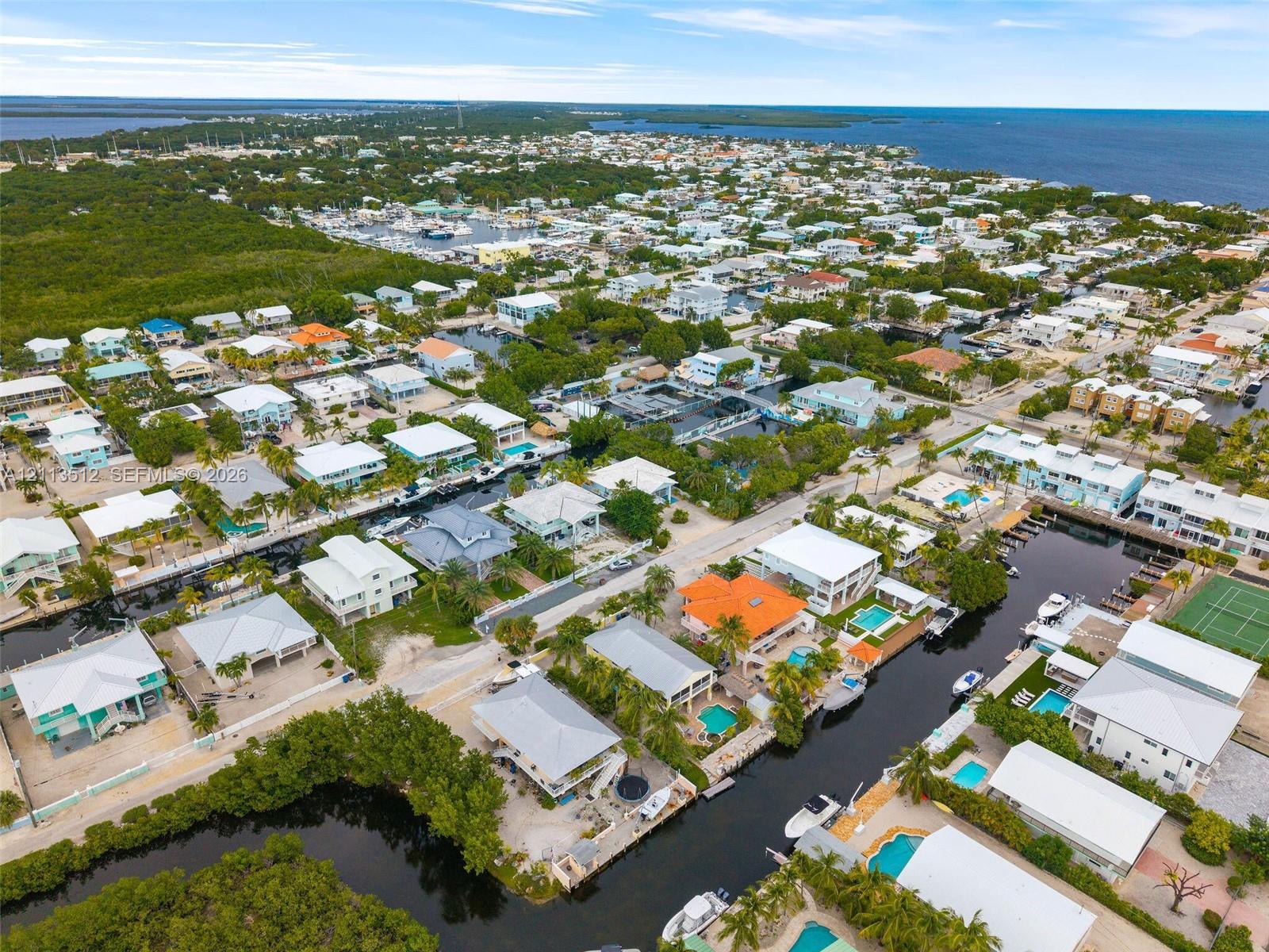 Aerial perspective of a coastal community featuring deep-water canal access, private boat docking, and open ocean exposure