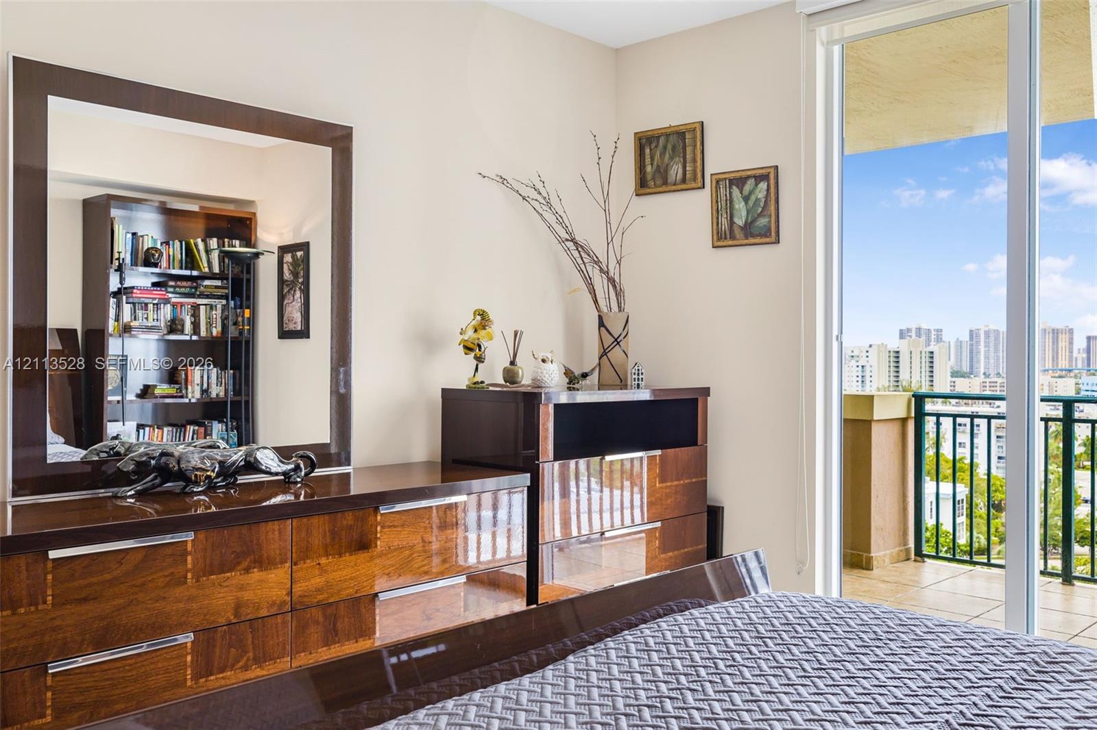 Floor-to-ceiling glass sliding door providing external access to a private balcony with metal railing