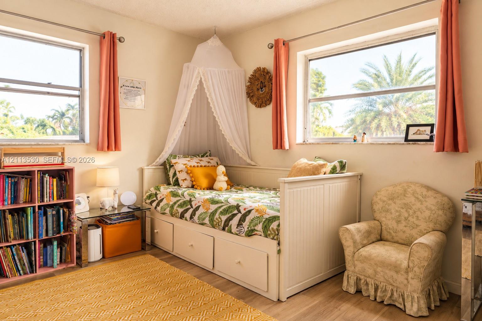 Neutral-toned interior featuring wood-finish flooring, dual windows with metallic hardware, and natural light exposure