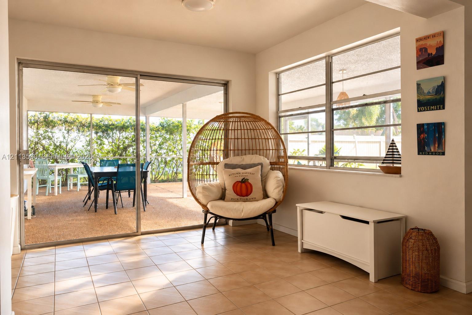Large ceramic floor tiling, expansive sliding glass doors, horizontal sliding windows, and a covered patio area with textured concrete surfacing