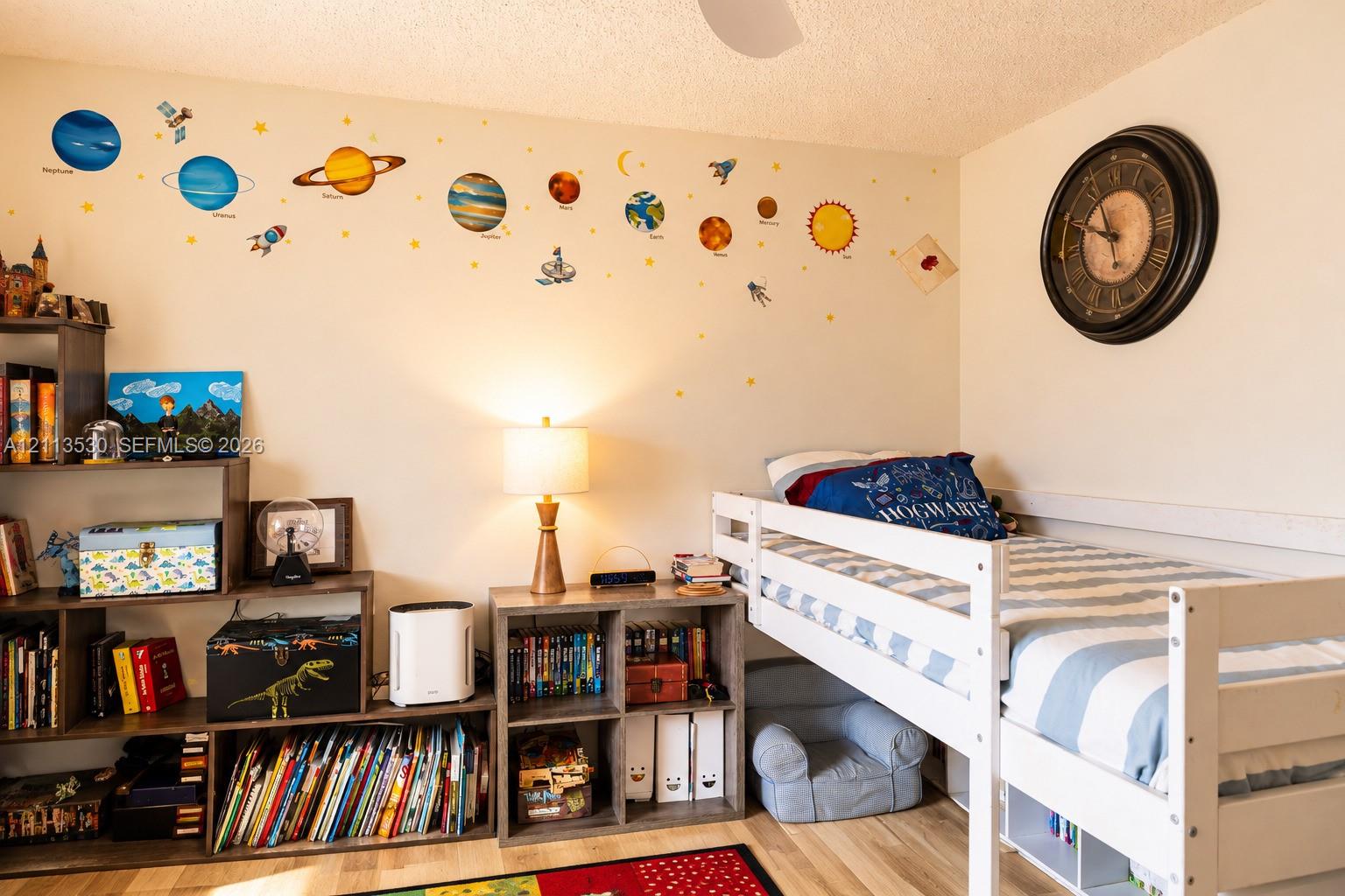 Room featuring wood-finish flooring and a circular wall-mounted clock