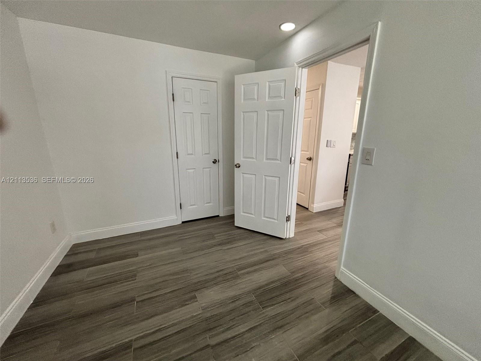 Wood-finish flooring, white six-panel interior doors, and recessed ceiling lighting Wood-finish flooring, white six-panel interior doors, and recessed ceiling lighting