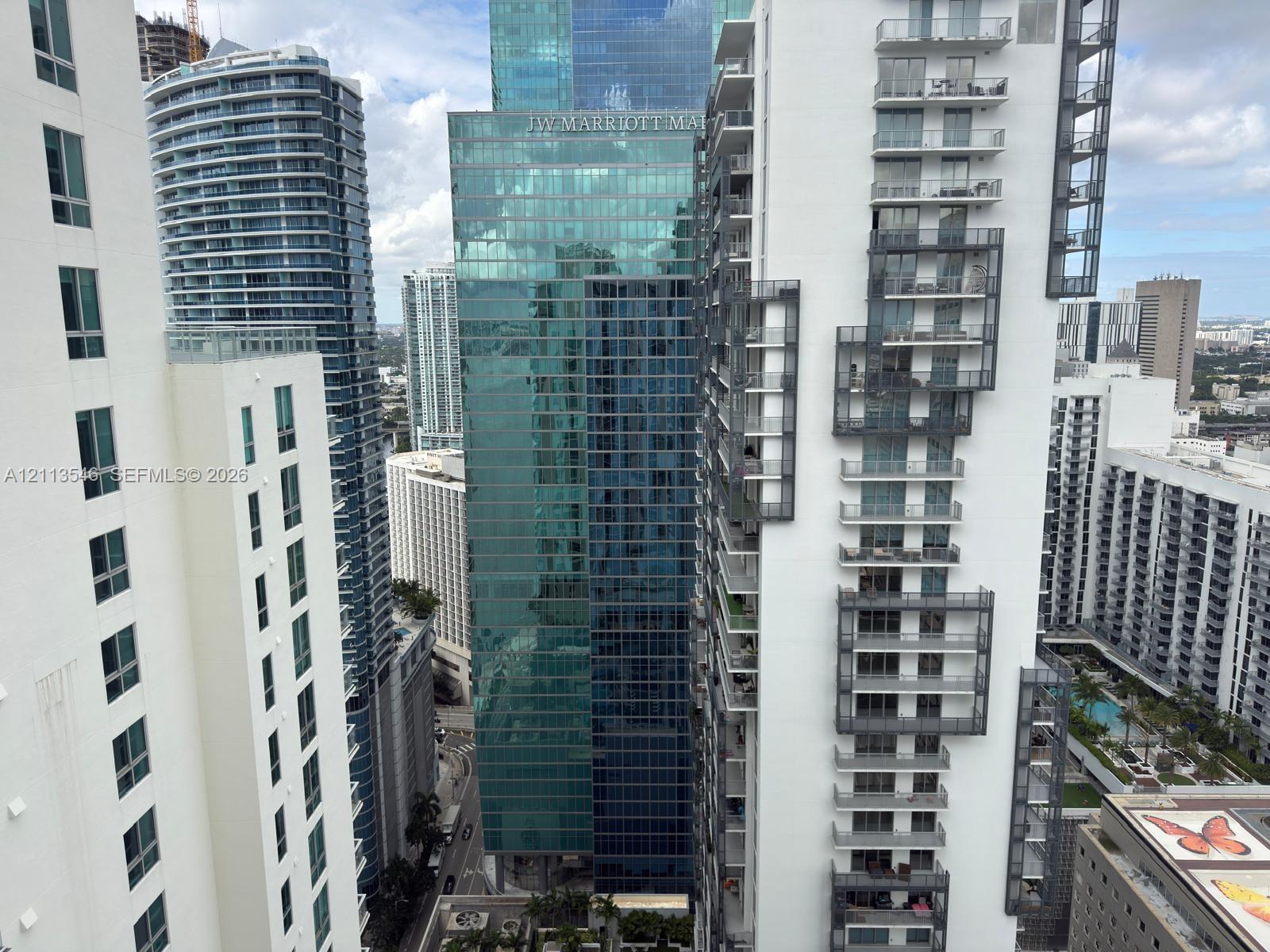 High-rise urban landscape featuring multiple glass-facade skyscrapers, architectural metal balconies, and dense metropolitan density High-rise urban landscape featuring multiple glass-facade skyscrapers, architectural metal balconies, and dense metropolitan density