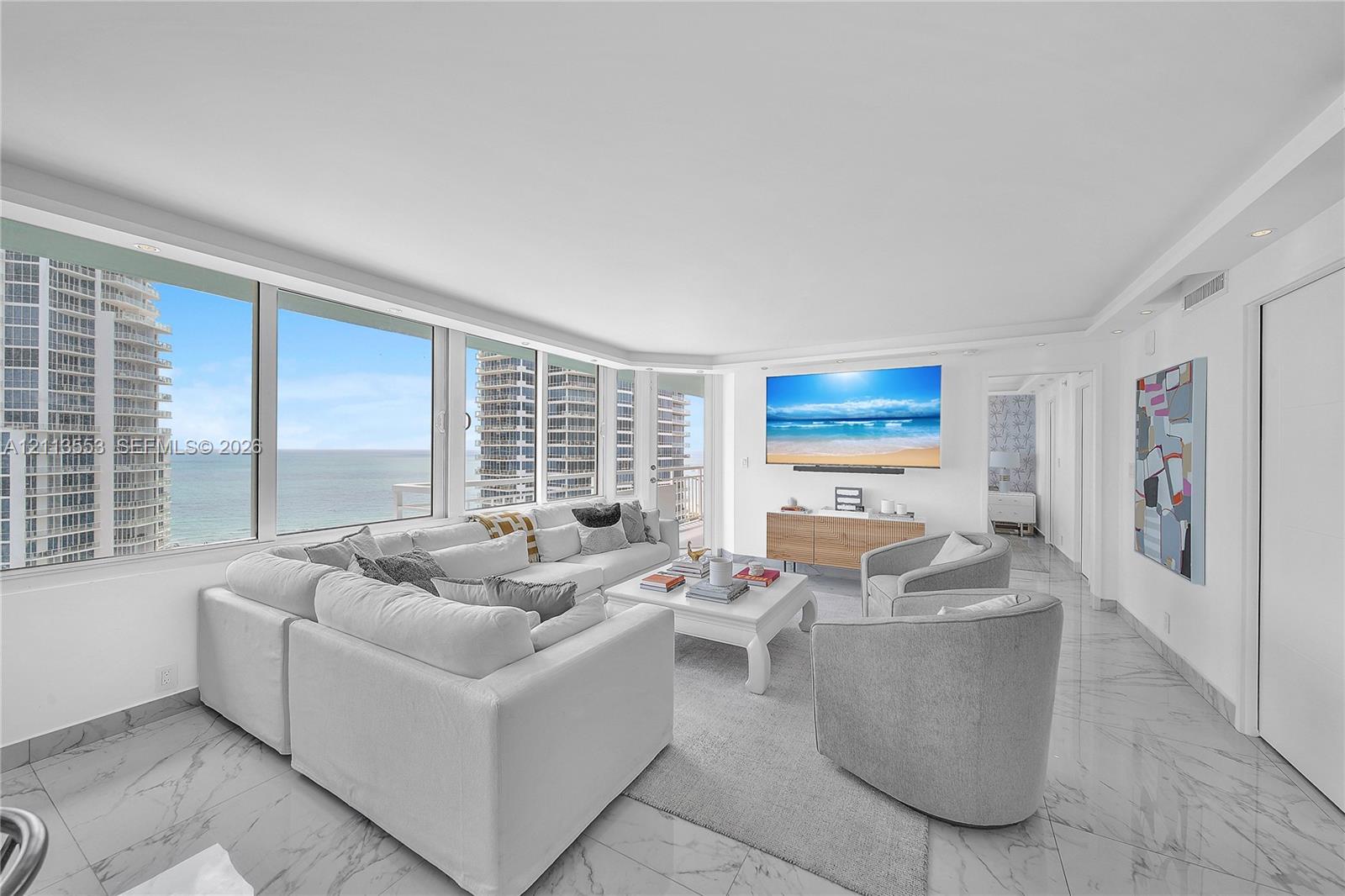 Floor-to-ceiling windows, stone-finish tile flooring, recessed lighting, and wall-mounted television console Floor-to-ceiling windows, stone-finish tile flooring, recessed lighting, and wall-mounted television console