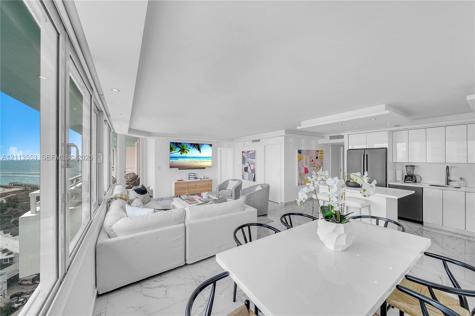 Open-concept interior featuring floor-to-ceiling windows, polished tile flooring, recessed lighting, and white gloss cabinetry Open-concept interior featuring floor-to-ceiling windows, polished tile flooring, recessed lighting, and white gloss cabinetry