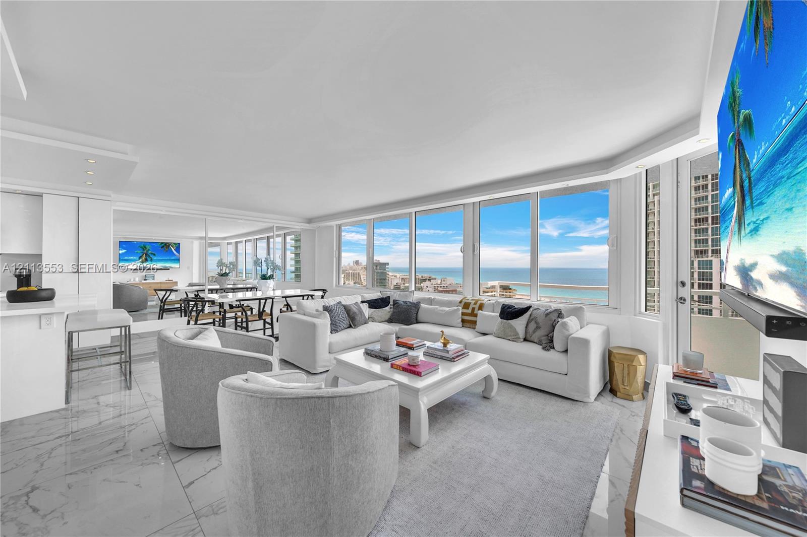 Open-concept living space featuring floor-to-ceiling windows, polished stone-finish flooring, recessed ceiling lighting, and a neutral color palette Open-concept living space featuring floor-to-ceiling windows, polished stone-finish flooring, recessed ceiling lighting, and a neutral color palette