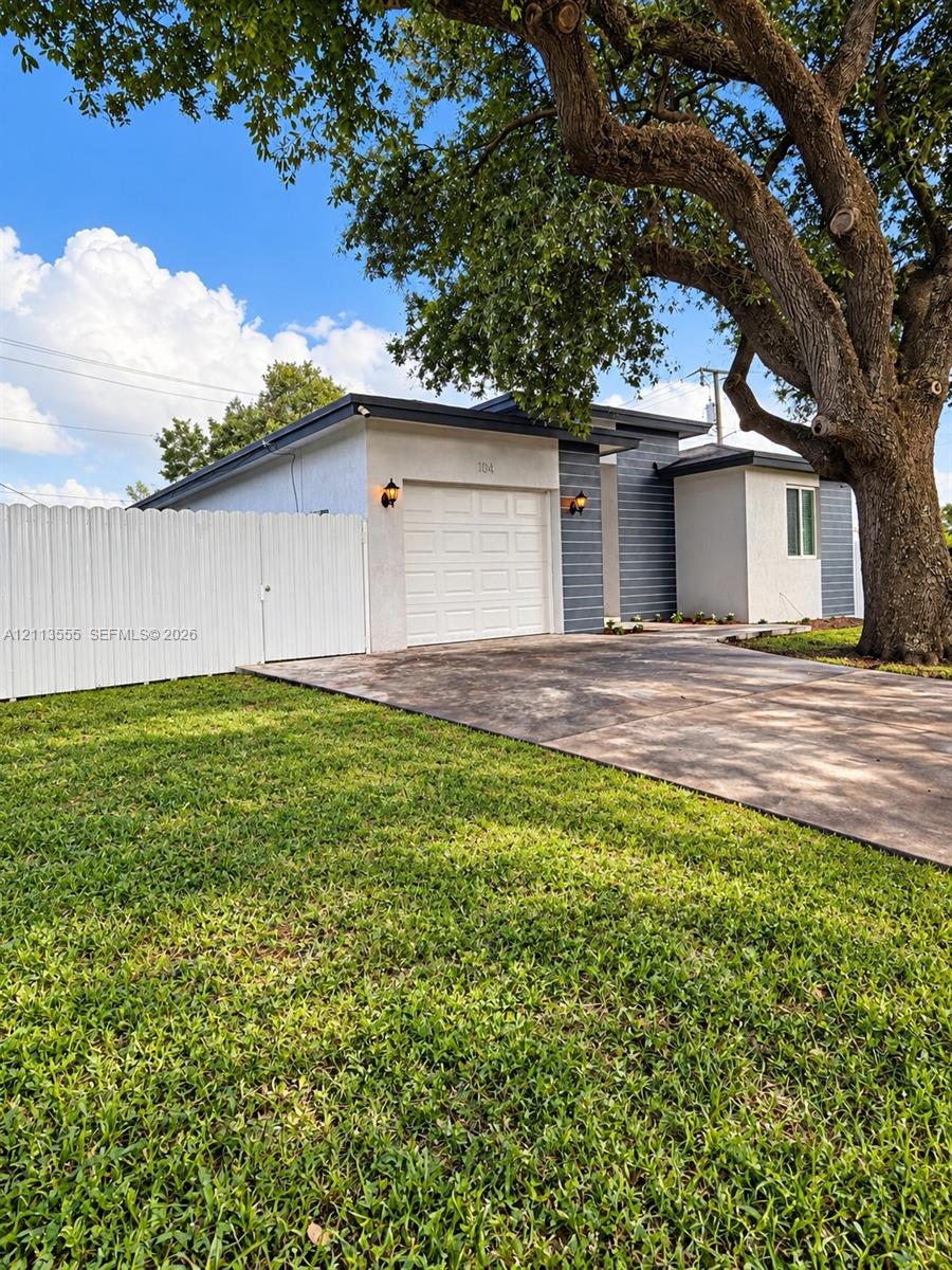 Single-story exterior featuring a stucco and horizontal siding facade, an attached garage, a concrete driveway, and a fenced perimeter Single-story exterior featuring a stucco and horizontal siding facade, an attached garage, a concrete driveway, and a fenced perimeter