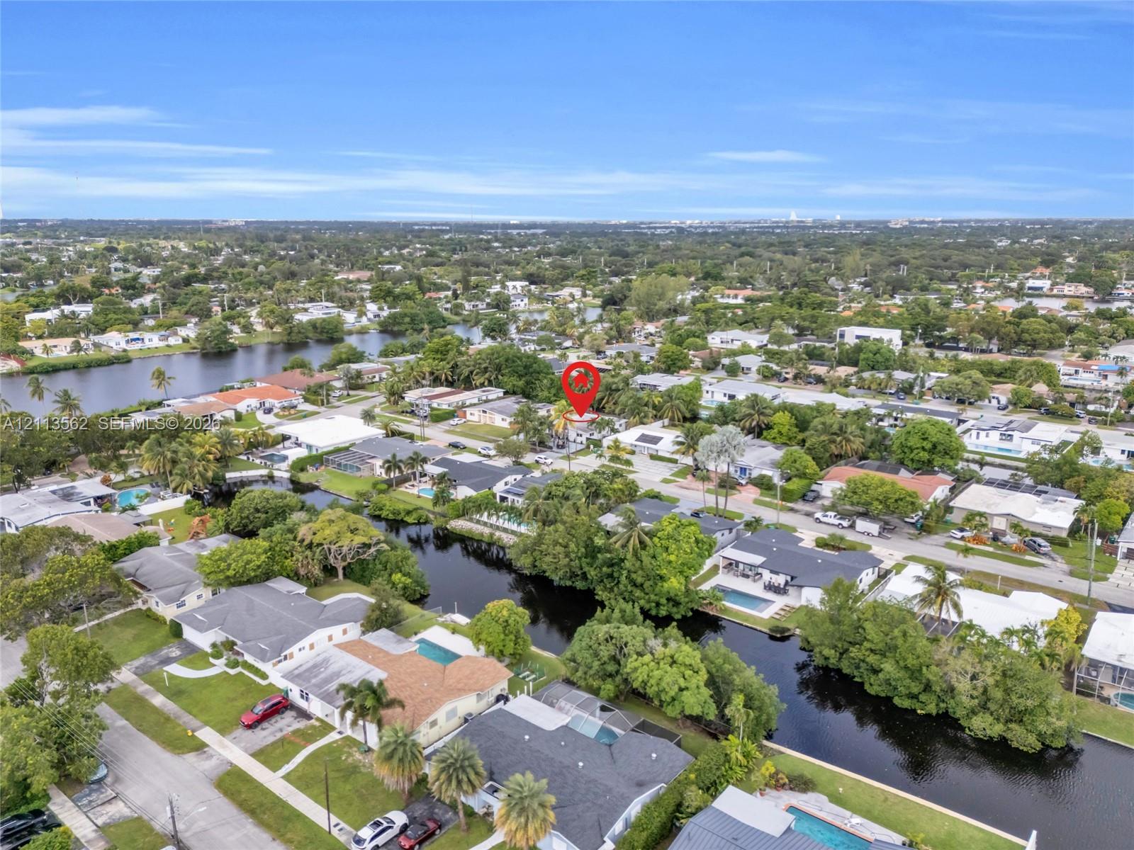 Aerial perspective of a residential lot situated within a waterfront community featuring canal access and mature palm landscaping