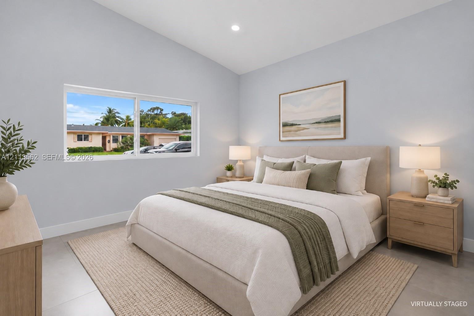 Vaulted ceilings, large sliding window, and neutral tile flooring