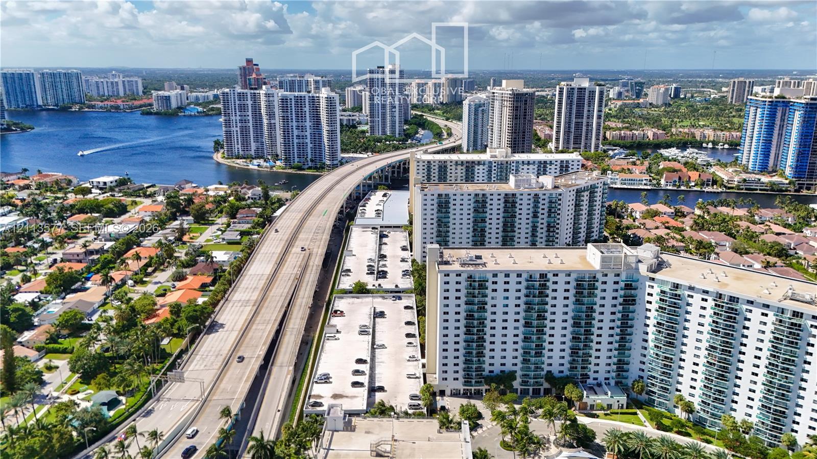 Aerial perspective featuring multi-story residential towers, coastal waterways, and proximity to infrastructure