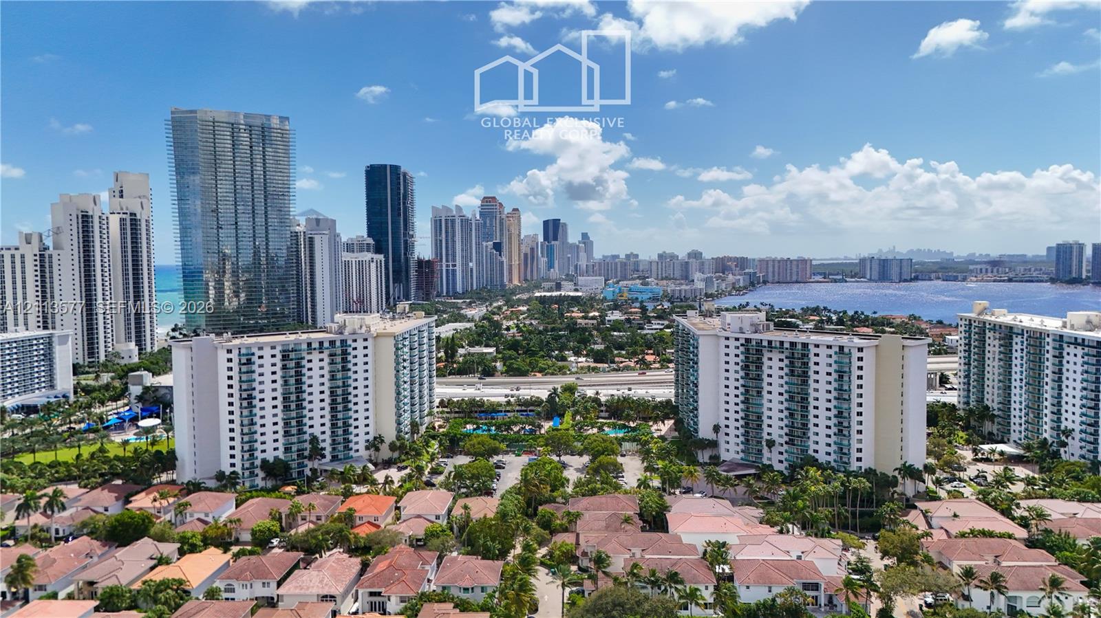 Aerial perspective of an urban skyline, high-rise buildings, coastal waterway, and residential properties