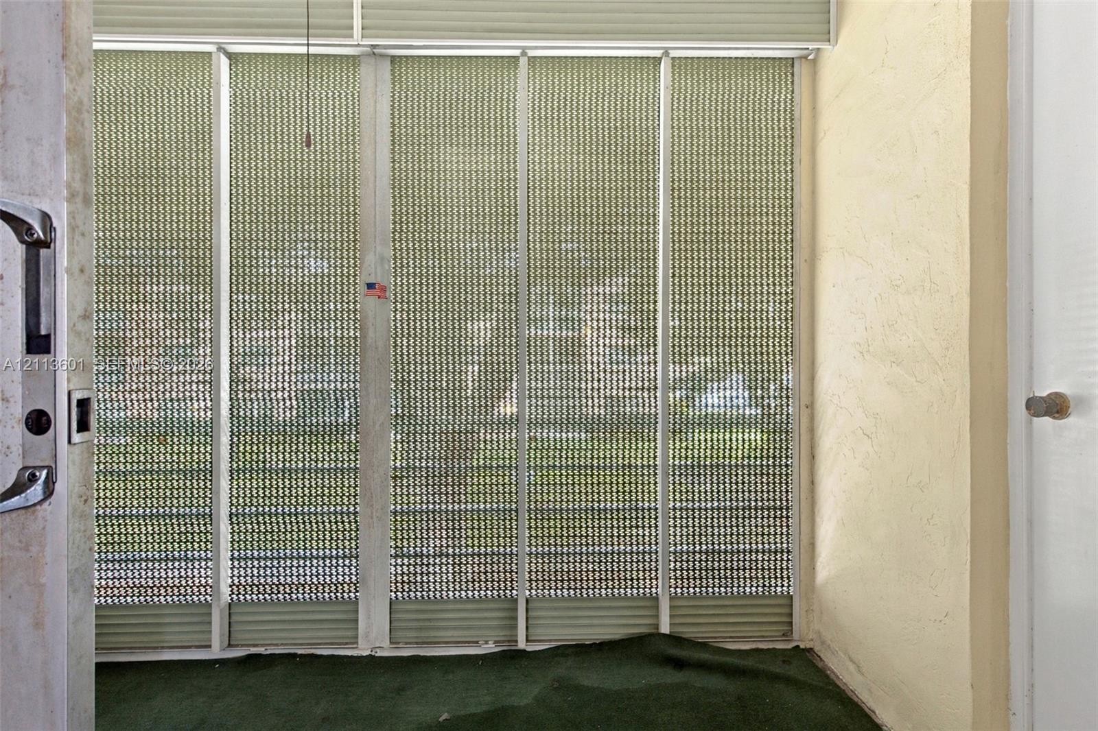 Enclosed porch featuring aluminum framing, integrated metal security screens, and textured wall finishes