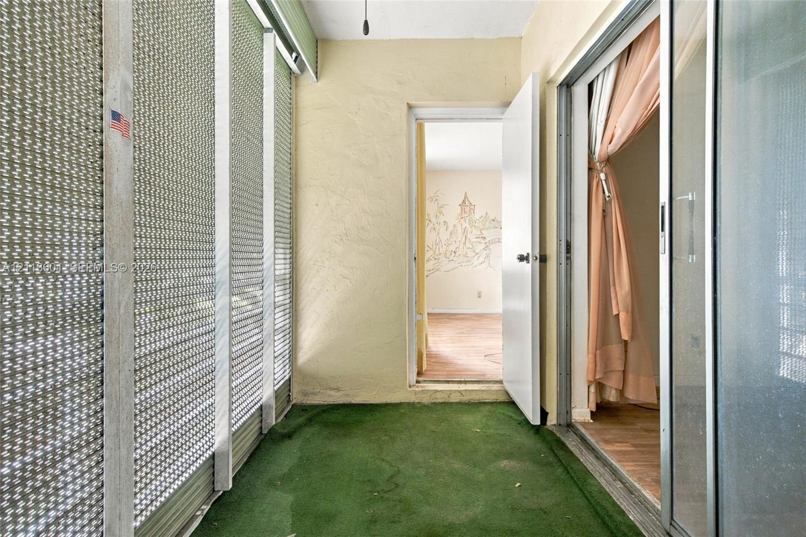 Enclosed porch featuring screen wall panels, textured wall finishes, and sliding glass entry doors