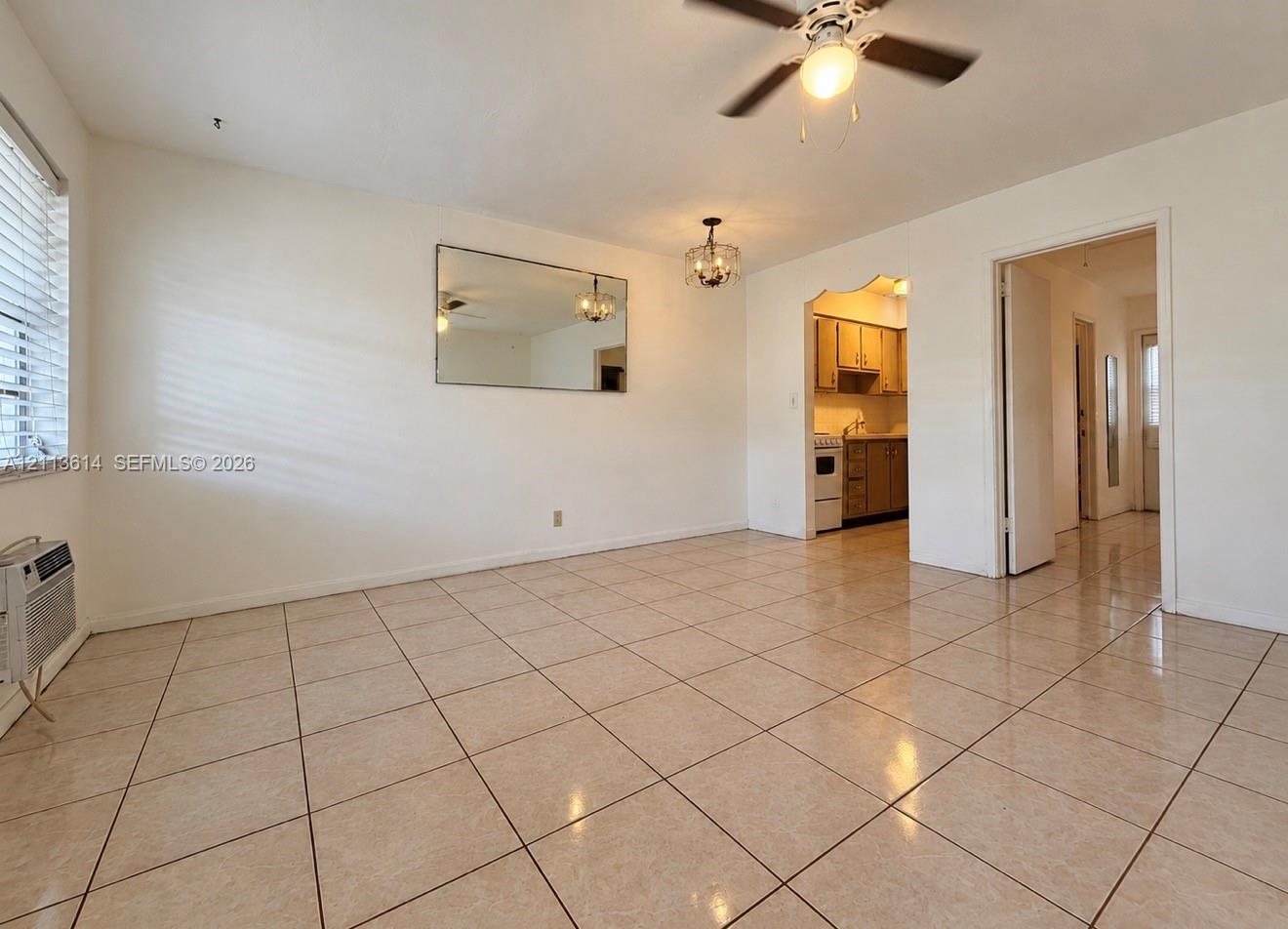Ceramic tile flooring, neutral wall finishes, integrated wall-mounted mirror, ceiling fan with light fixture, and arched entryway Ceramic tile flooring, neutral wall finishes, integrated wall-mounted mirror, ceiling fan with light fixture, and arched entryway