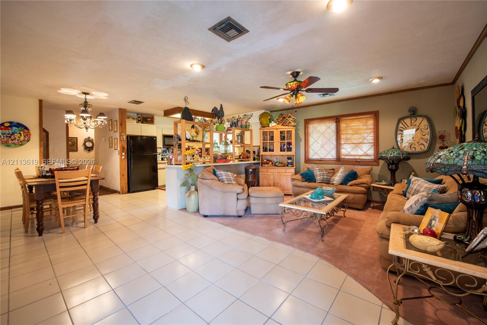 Open floor plan featuring tile flooring, built-in wooden cabinetry, recessed lighting, and a ceiling fan Open floor plan featuring tile flooring, built-in wooden cabinetry, recessed lighting, and a ceiling fan