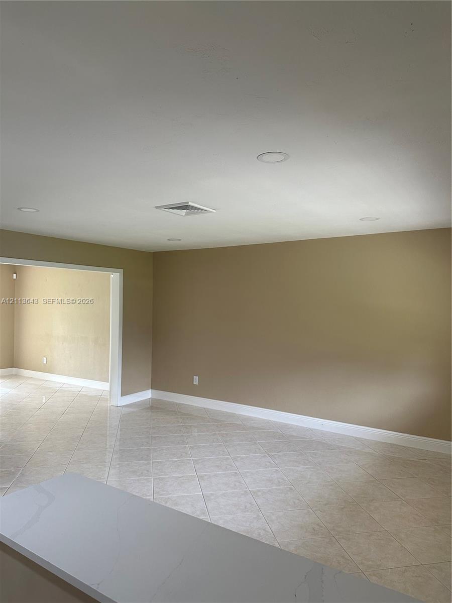 Neutral-toned interior featuring diagonal tile flooring and recessed ceiling lighting