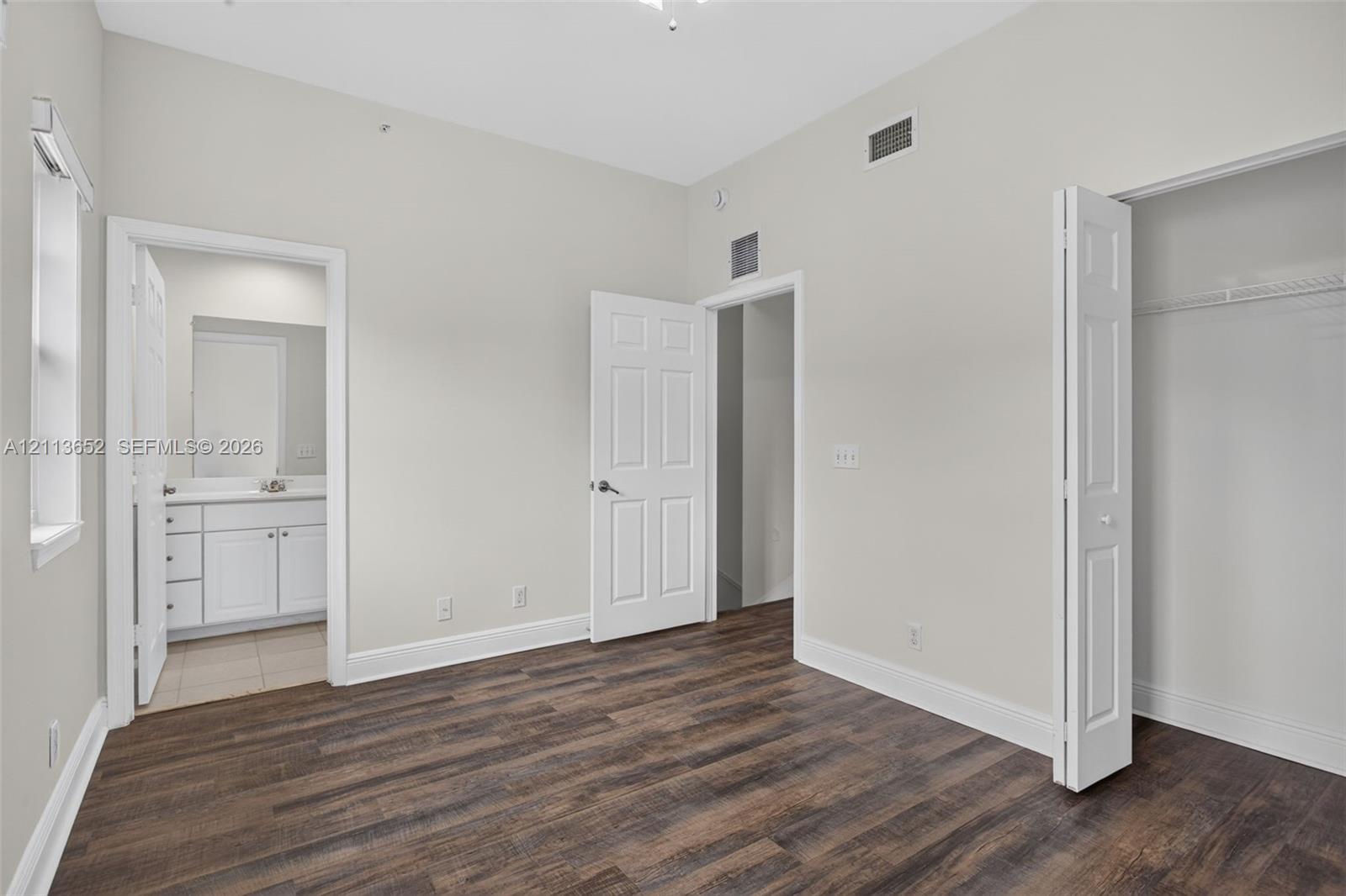 Interior space featuring wood-finish flooring, six-panel interior doors, and a closet with bifold doors