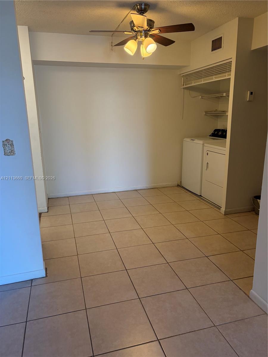 Ceramic tile flooring, ceiling fan with integrated lighting, and built-in laundry alcove with overhead shelving