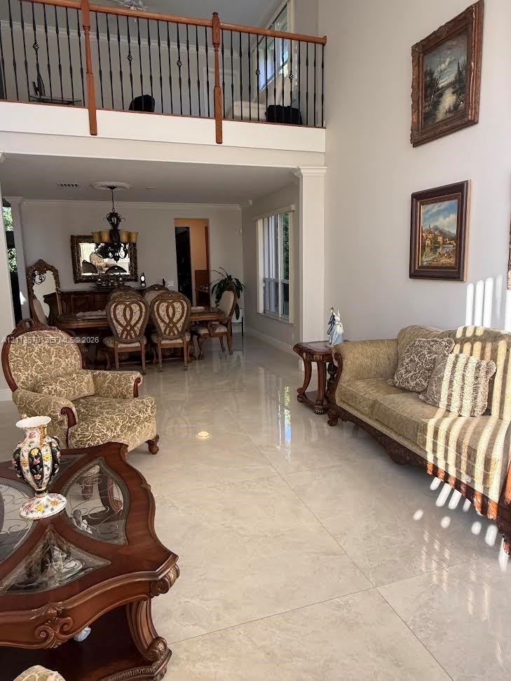 Two-story ceiling height, polished large-format tile flooring, and a mezzanine featuring decorative metal railing Two-story ceiling height, polished large-format tile flooring, and a mezzanine featuring decorative metal railing