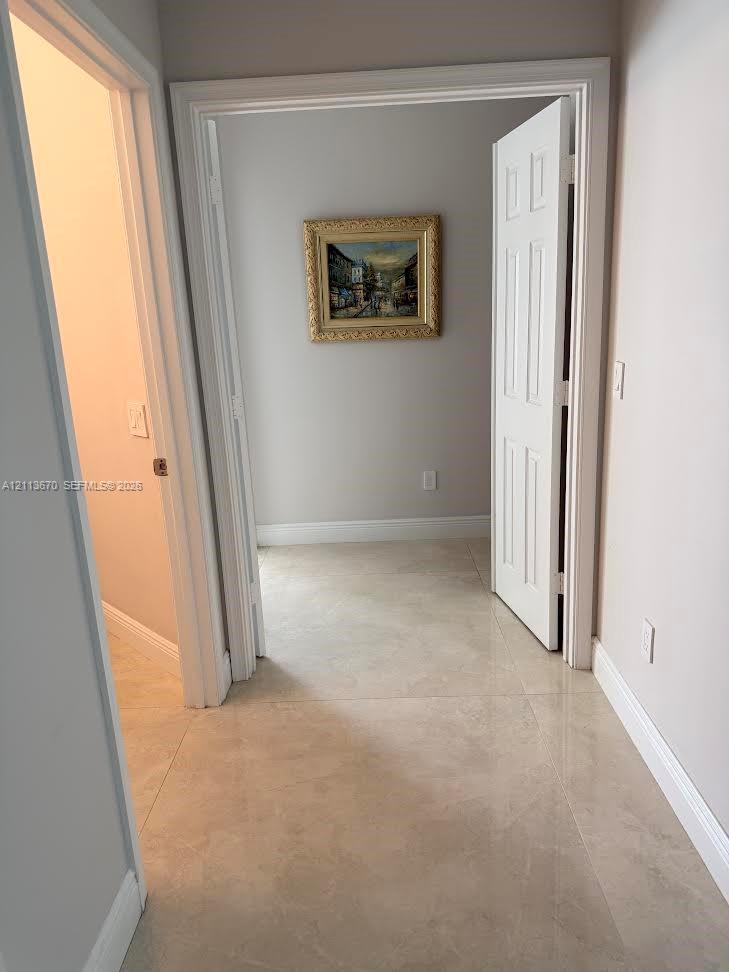 Neutral-toned tile flooring, six-panel interior doors, and neutral wall paint Neutral-toned tile flooring, six-panel interior doors, and neutral wall paint