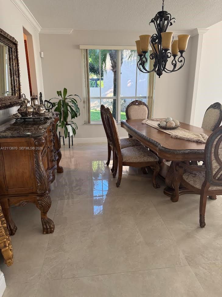 Large-format polished tile flooring, decorative wrought-iron chandelier, and multi-pane window with crown molding Large-format polished tile flooring, decorative wrought-iron chandelier, and multi-pane window with crown molding