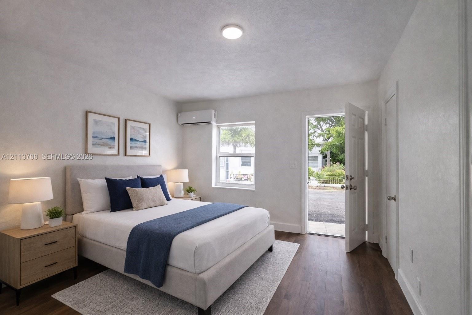 Wood-finish flooring, wall-mounted ductless climate control unit, single-hung window, and swinging exterior entry door Wood-finish flooring, wall-mounted ductless climate control unit, single-hung window, and swinging exterior entry door