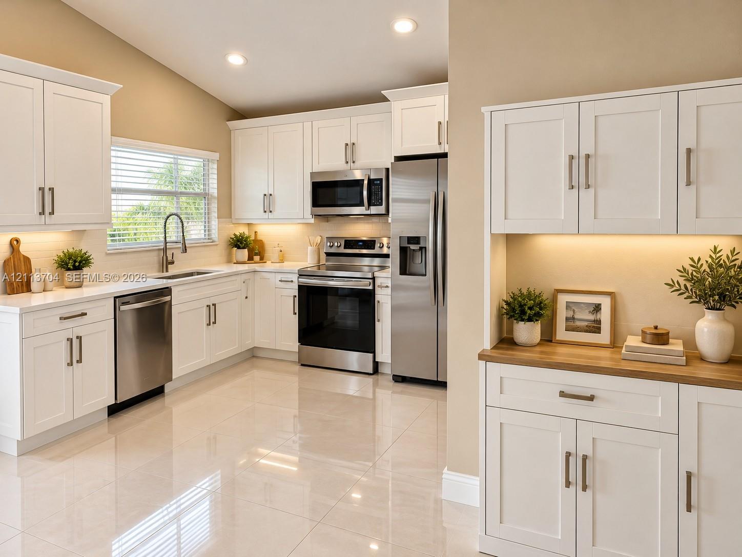 Kitchen featuring white shaker-style cabinetry, stainless steel appliances, polished tile flooring, under-cabinet lighting, and a wood-finish countertop