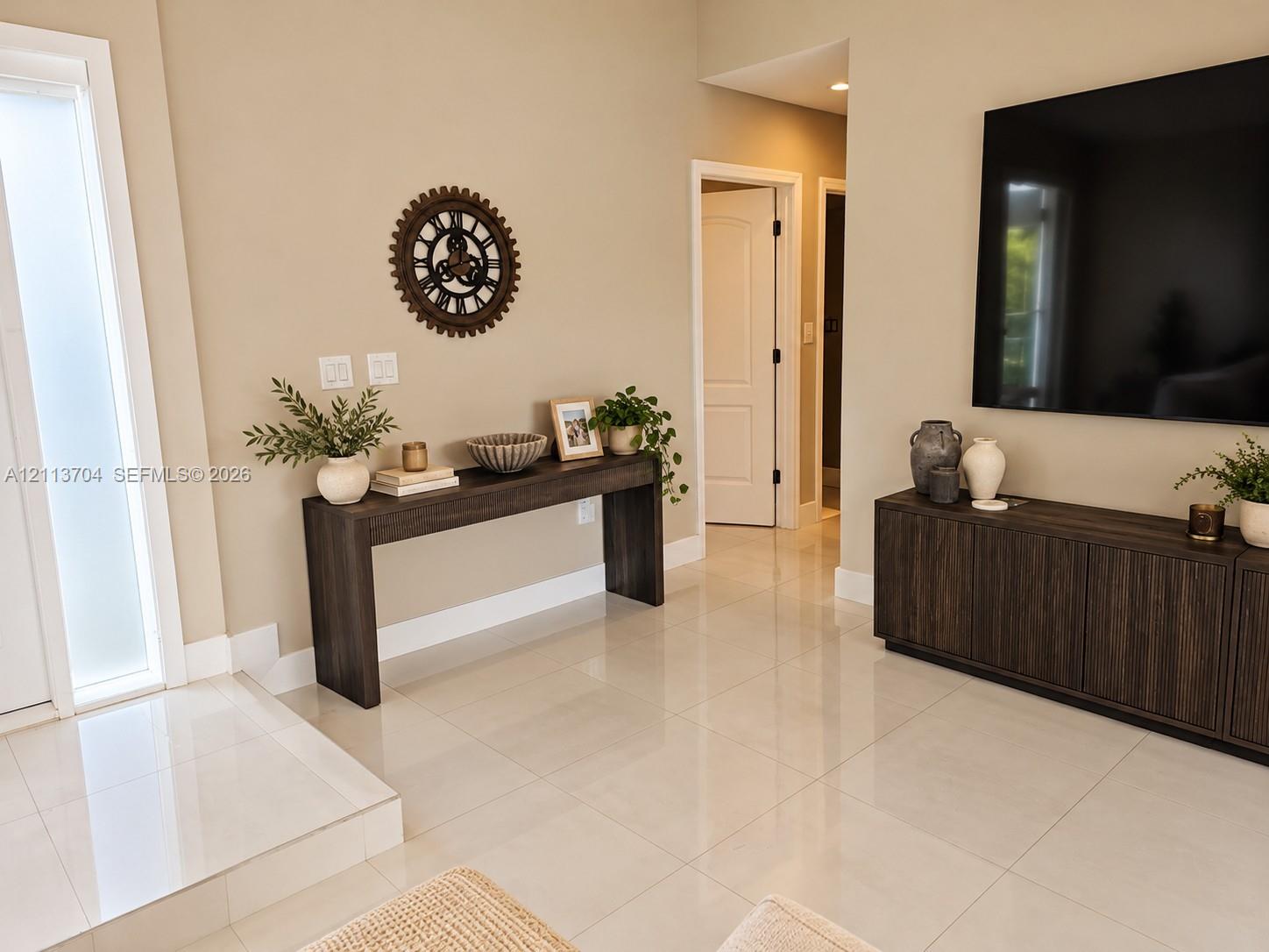 Polished light-toned tile flooring, door with frosted glass panel, and neutral wall color Polished light-toned tile flooring, door with frosted glass panel, and neutral wall color