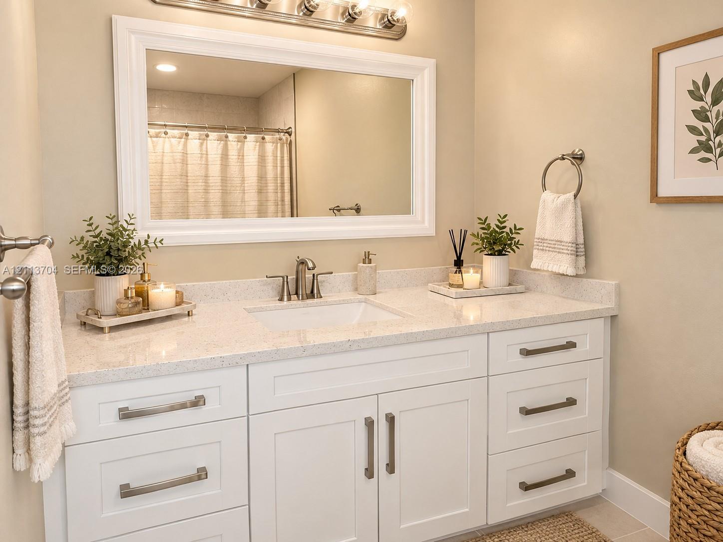 White shaker-style vanity featuring a speckled composite countertop, an undermount sink, brushed nickel hardware, and a large framed mirror