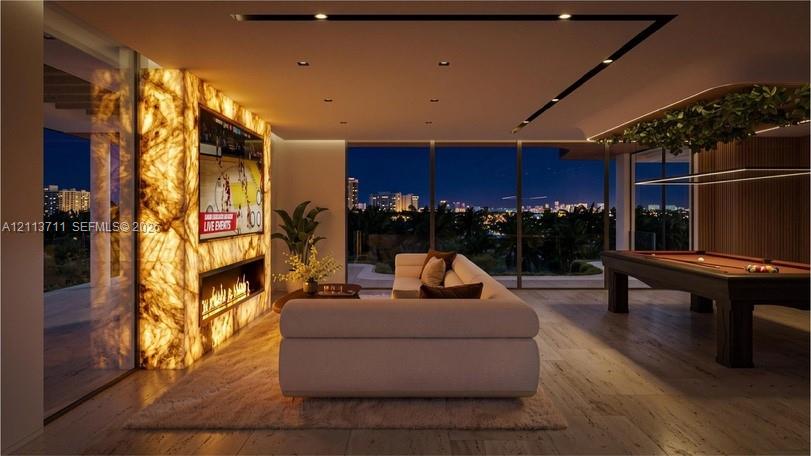 Illuminated natural stone wall feature with integrated linear fireplace, floor-to-ceiling glass wall panels, recessed ceiling lighting, and wood-finish flooring