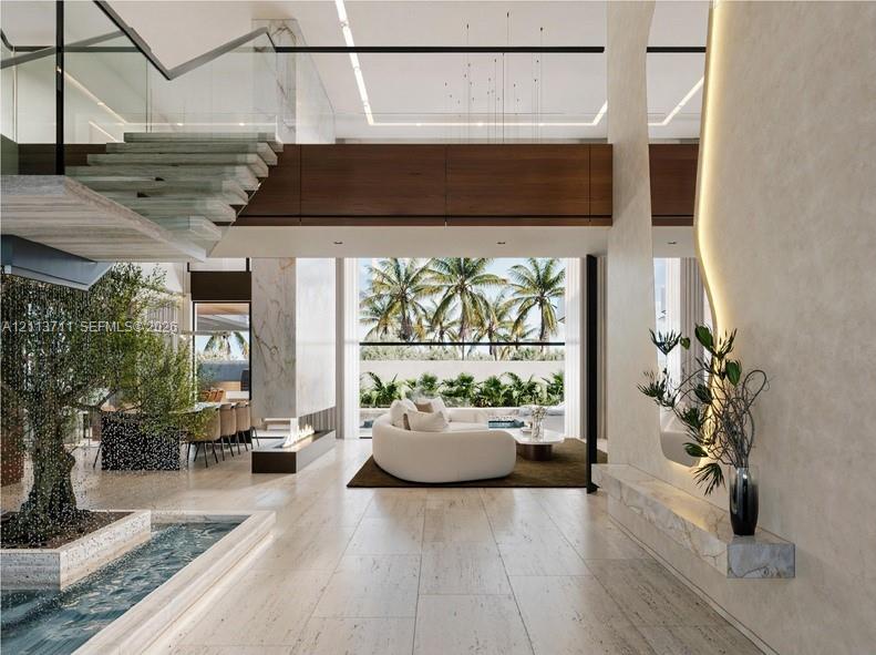 Open-concept interior featuring light stone flooring, a floating staircase with glass railings, a built-in stone water feature, a linear fireplace, and integrated accent lighting