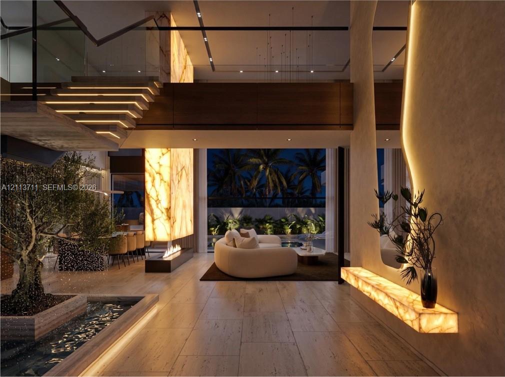 Open-concept living space featuring wood-finish flooring, a full-height backlit stone accent wall, a floating staircase with integrated lighting, and an indoor reflecting pool