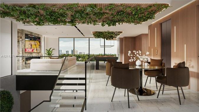 Open-concept interior featuring light-toned stone flooring, floor-to-ceiling windows, slatted wood-finish wall paneling, a stone-surround fireplace, and a glass-paneled staircase