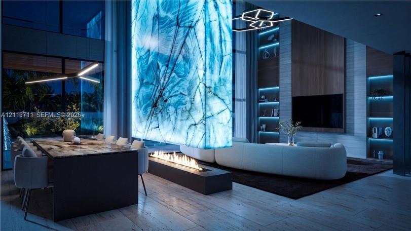 Double-height space featuring a backlit stone-slab accent wall, linear gas fireplace, integrated LED display shelving, and wood-finish flooring