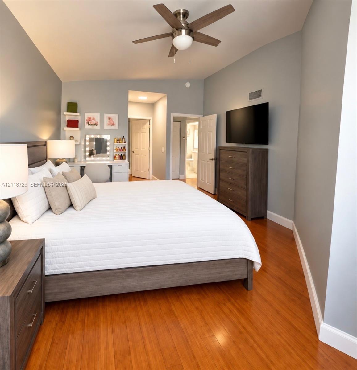 Wood-finish flooring, neutral wall tones, and ceiling fan with integrated lighting