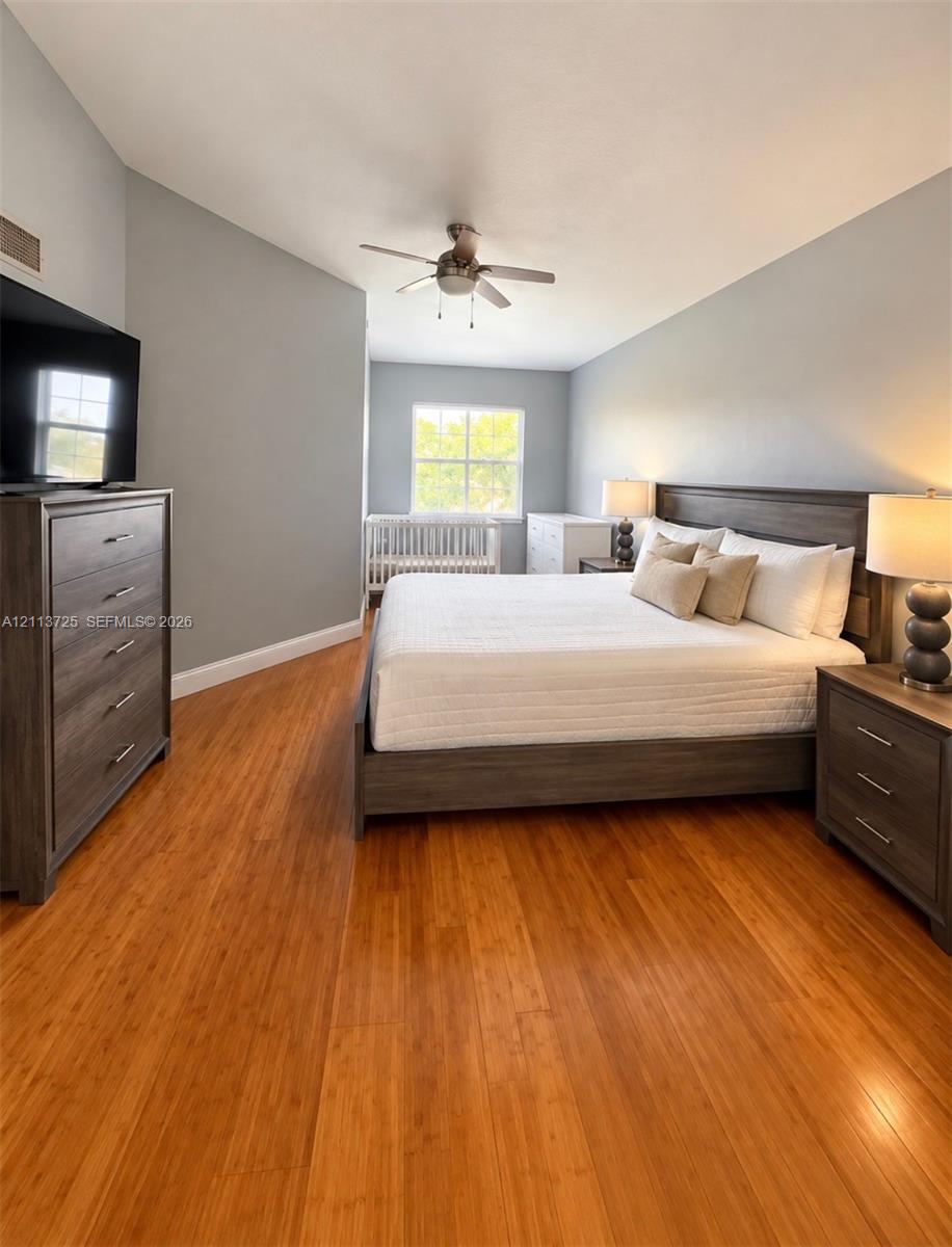 Room featuring wood-finish flooring, vaulted ceiling, and a ceiling fan