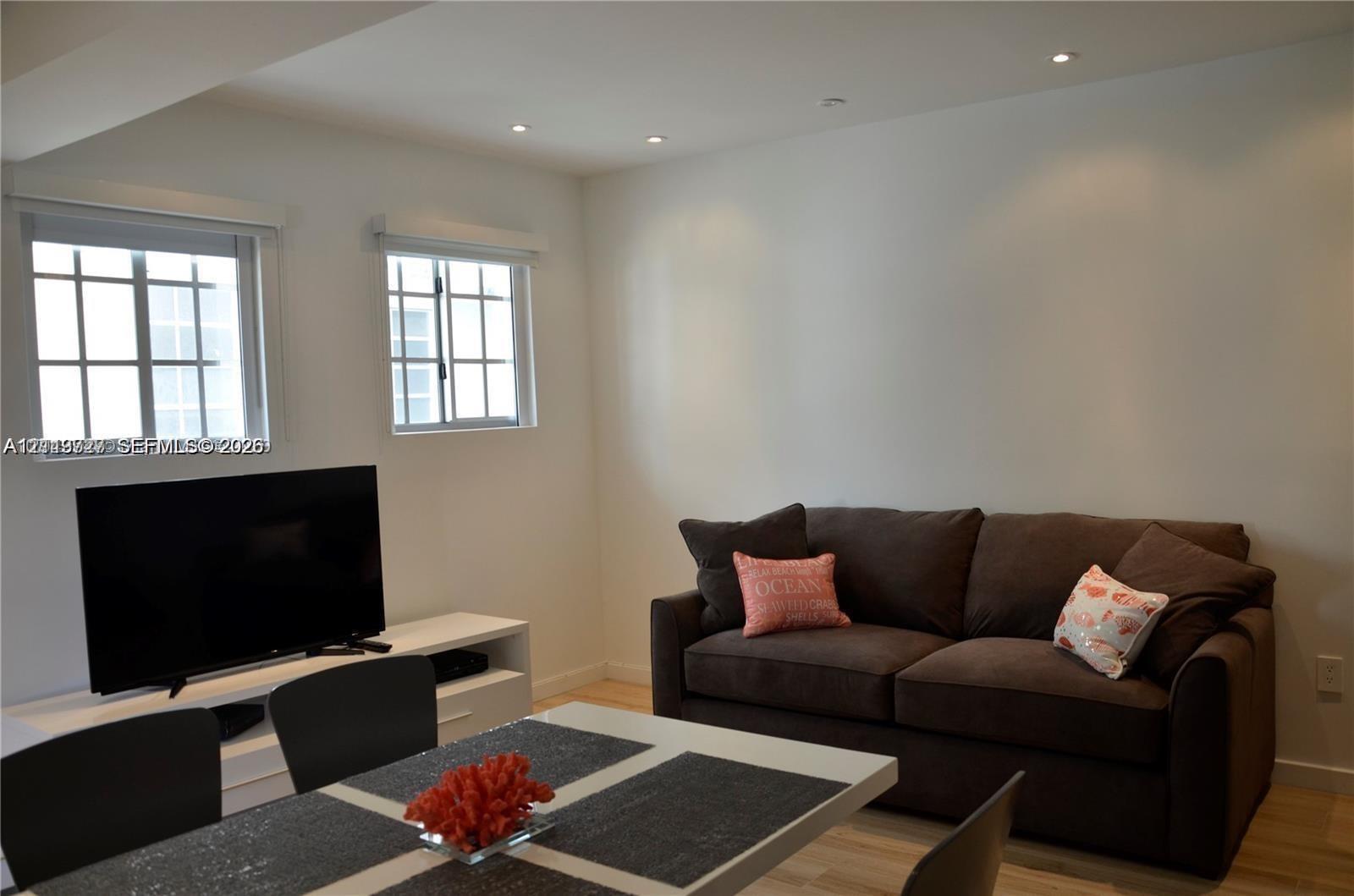 Bright room featuring recessed ceiling lighting, wood-finish flooring, and multi-pane windows Bright room featuring recessed ceiling lighting, wood-finish flooring, and multi-pane windows