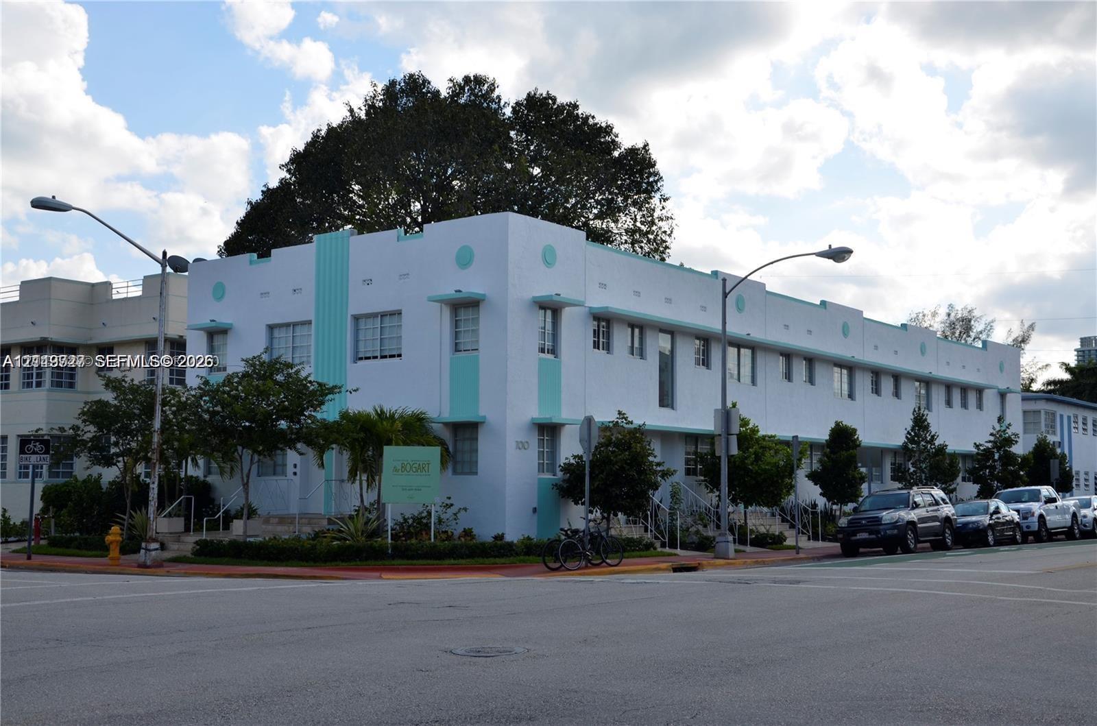 Art Deco building exterior featuring a geometric stucco facade, decorative horizontal bands, cantilevered window awnings, and multi-pane casement windows
