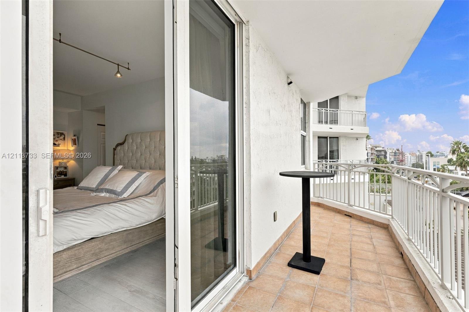 Private balcony featuring tile flooring and white metal railing, accessed through sliding glass doors