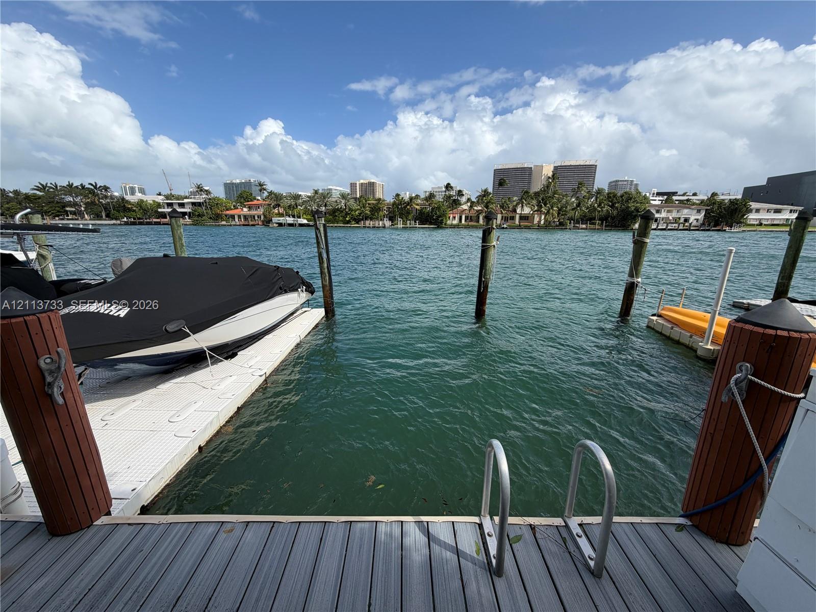 Waterfront bulkhead with integrated synthetic decking, pile-mounted mooring pilings, and stainless steel swimming ladder