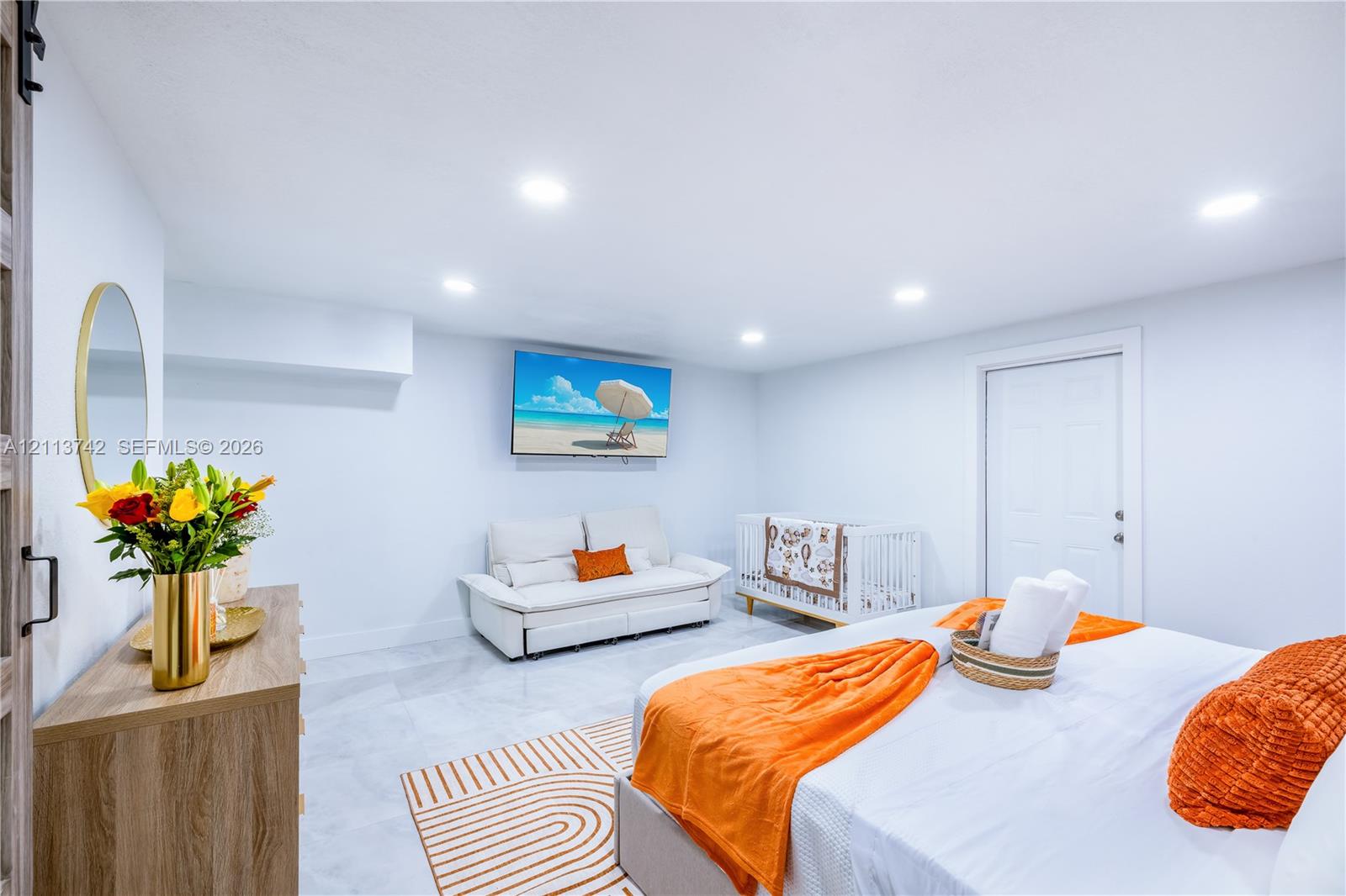 Neutral-toned room featuring recessed lighting, smooth-finish walls, polished tile flooring, and a wall-mounted sliding door