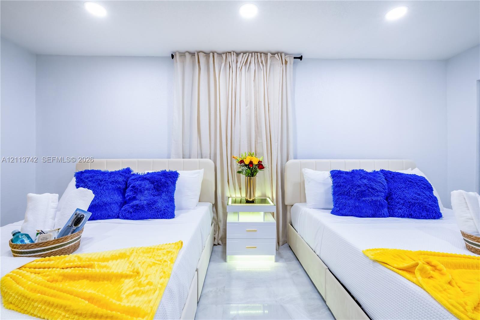 Recessed ceiling lighting, glossy light-toned flooring, and a central built-in nightstand with integrated under-shelf illumination