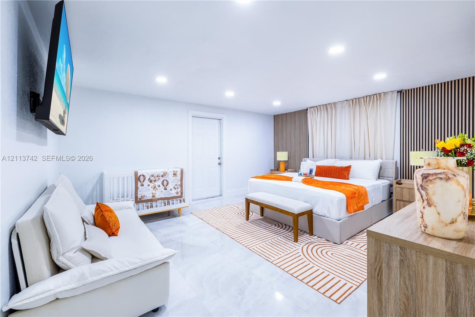 Sleek room featuring polished tile flooring, recessed ceiling lighting, and a decorative wood-slat accent wall
