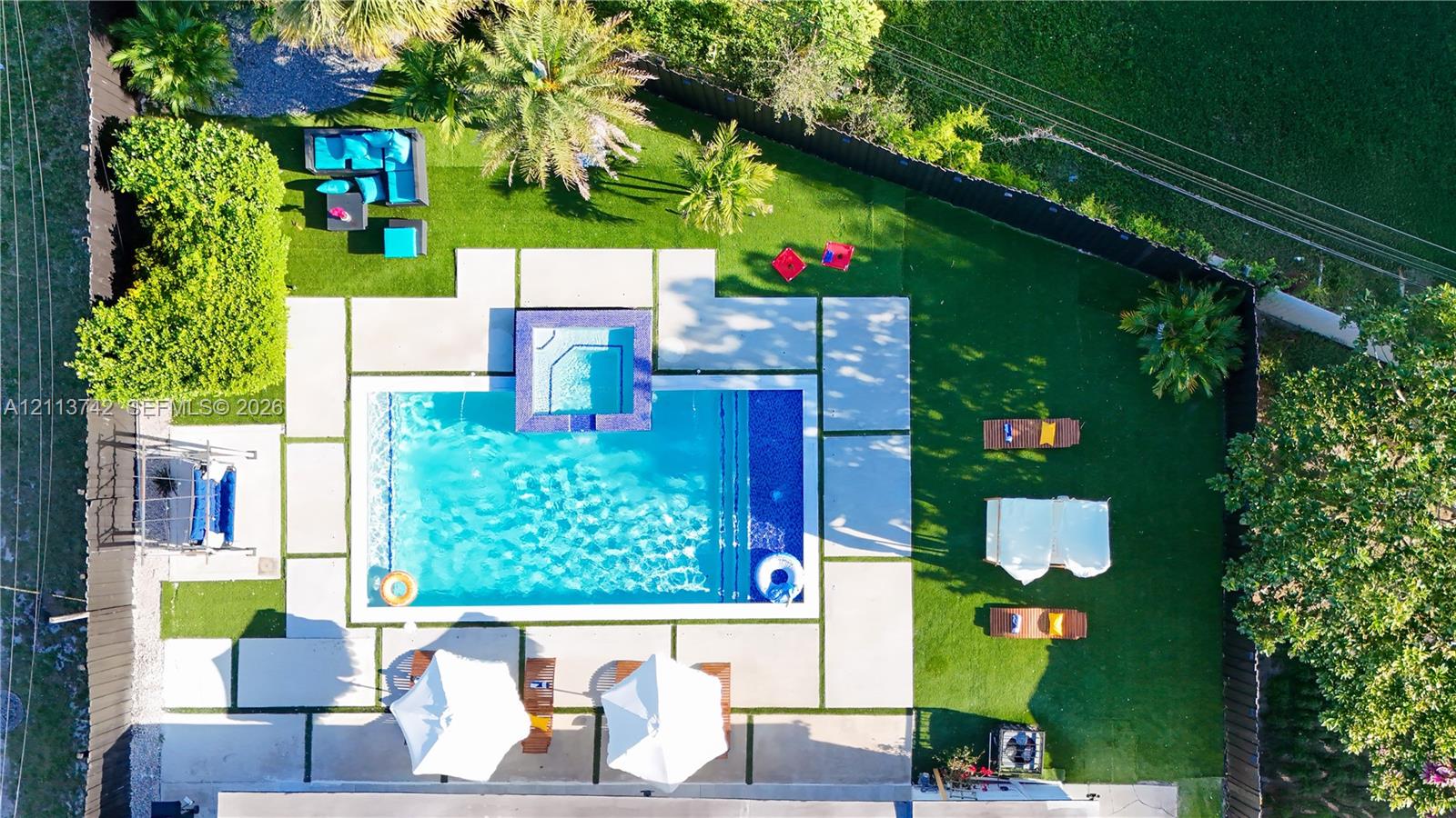 Backyard featuring a swimming pool with integrated spa, concrete paver decking, and manicured turf Backyard featuring a swimming pool with integrated spa, concrete paver decking, and manicured turf