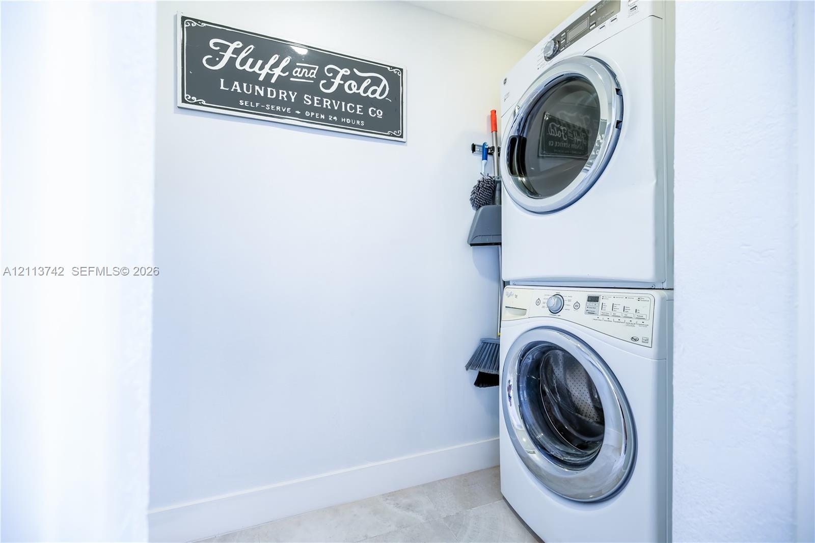 Laundry closet featuring a white stacked washer and dryer set