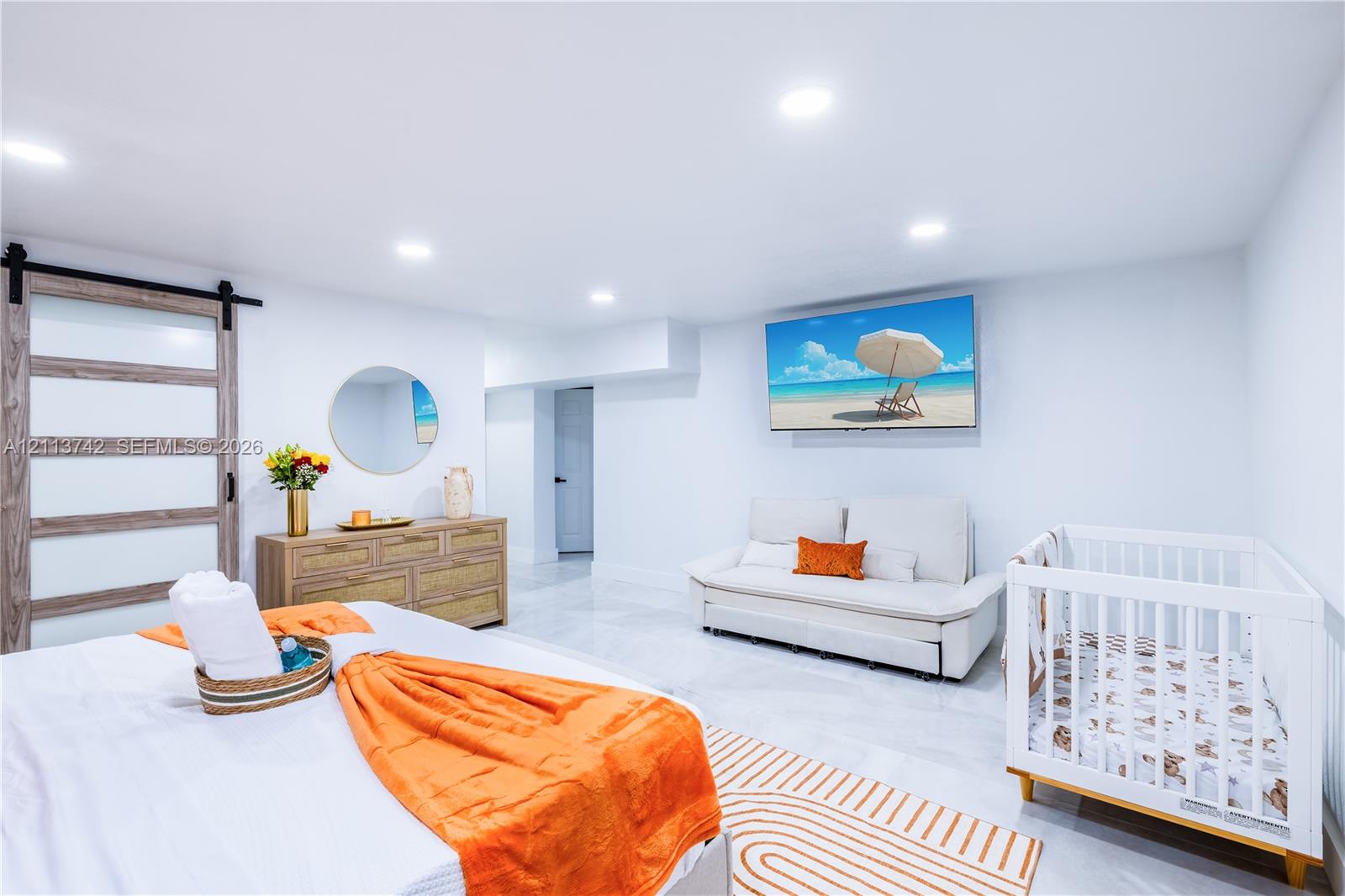 Interior space featuring a sliding barn door with glass panels, large-format tile flooring, and recessed ceiling lighting