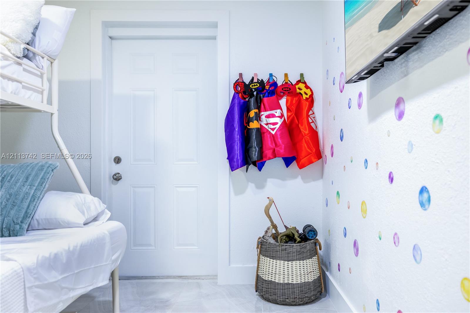 Interior room featuring six-panel door with brushed metal hardware and neutral tile flooring