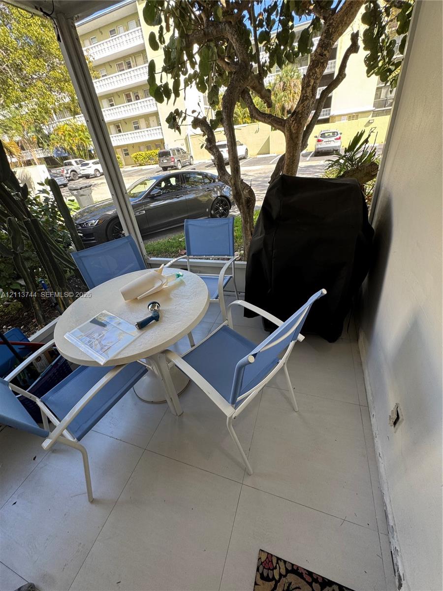 Screened-in patio featuring large-format tile flooring and vertical mesh enclosure