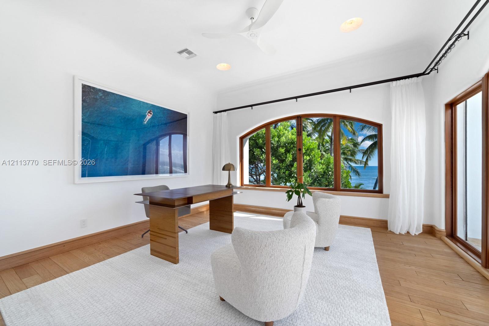 Room featuring wood-finish flooring, an arched window with wood trim, ceiling fan, and recessed lighting